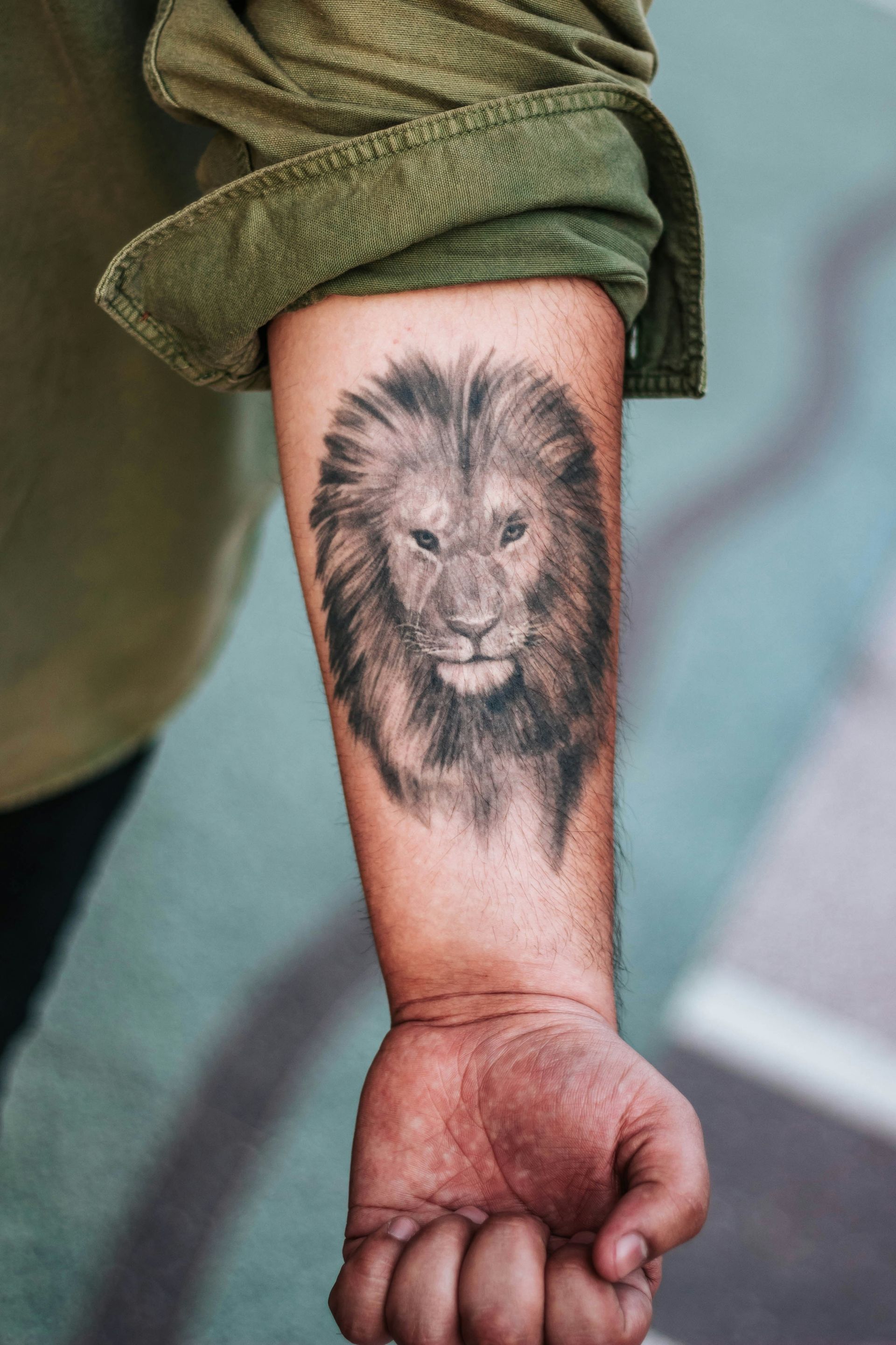 shallow focus photography of lion forearm tattoo